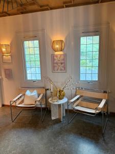 a room with two chairs and a table and two windows at Ewa & Maude Hotel in Gothenburg
