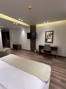 a room with a bed and a desk and a mirror at Lake Plaza Hotel in Borg El Arab