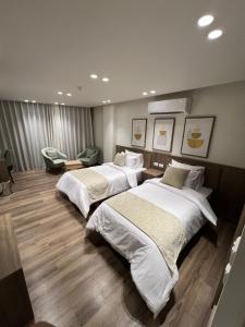 two beds in a hotel room with at Lake Plaza Hotel in Borg El Arab +70 photos