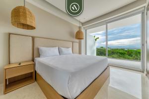 a bedroom with a white bed and a large window at New 3BR Condo - Oceanview Terrace - Private Beach in Higuera Blanca +37 photos