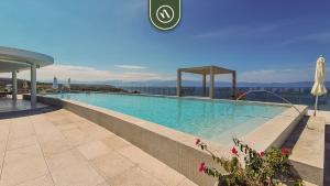 a large swimming pool on top of a building at New 3BR Condo - Oceanview Terrace - Private Beach in Higuera Blanca