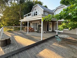 a house with a deck with a table and chairs at Clementine Cottage in Citrusdal