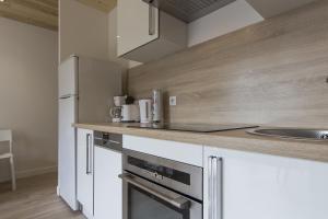 a kitchen with white cabinets and stainless steel appliances at Résidence Les Periades - Chamonix in Chamonix-Mont-Blanc