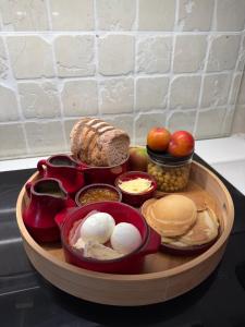 ein Tablett mit Essen mit Brot, Äpfeln und anderen Lebensmitteln in der Unterkunft La chambre clé de la forêt in Métairies-Saint-Quirin