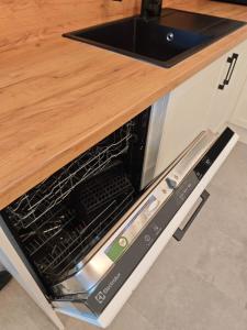 a microwave oven with its door open in a kitchen at Dióliget Apartman in Orfű