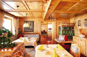 un comedor con mesas y sillas en una cabaña en Appartement Hotel Garni Matthäuserhof, en Gerlos