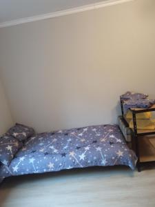 a bedroom with a bed with a blue comforter at studio with a fireplace in Zugdidi