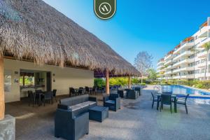a resort with chairs and tables and a swimming pool at 2BR Condo with Private Terrace - Near to the Beach in Nuevo Vallarta 