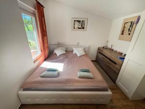 a bedroom with a bed in a room with a window at Badacsony Hegypanoráma Apartman in Badacsony