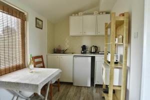 a kitchen with white cabinets and a table and a table and chair at Badacsony Hegypanoráma Apartman in Badacsony +40 photos