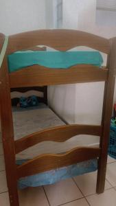 a wooden bunk bed with a green pillow on it at Apê da VAN in Garanhuns