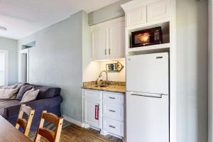 a kitchen with a white refrigerator next to a couch at Lost Colony Lost Sea Turtle in Port Aransas