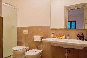 a bathroom with a sink and a toilet and a mirror at Policaretto Rooms by Calabria Stay in Torretta +3 photos