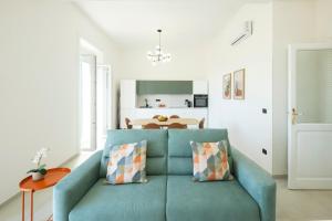 サレルノにあるMAREA Sea View Apartmentの青いソファとキッチンのあるリビングルーム