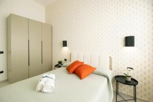 サレルノにあるMAREA Sea View Apartmentのオレンジ色の枕が付いた大きな白いベッドのある寝室