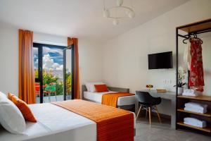 a hotel room with two beds and a desk and a window at Policaretto Rooms by Calabria Stay in Torretta