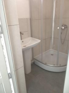a white bathroom with a sink and a shower at studio with a fireplace in Zugdidi