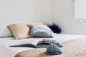a book and pair of shoes on a bed at Porto Rotondo sul Mare in Olbia