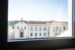 una ventana con vistas a un gran edificio blanco en versão b, en Ansião