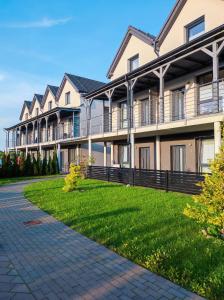 a large apartment building with a green lawn at Apartament KaJa in Rewal