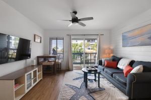 a living room with a couch and a ceiling fan at Fin's Watch in Tybee Island