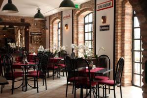 a restaurant with red tables and chairs and brick walls at Hotel Kameleon in Tarnobrzeg