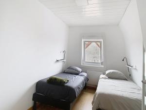 Un dormitorio con dos camas y una ventana. en Le refuge de Gavrelle, en Gavrelle