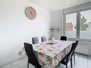 comedor con mesa y reloj en la pared en Le refuge de Gavrelle, en Gavrelle