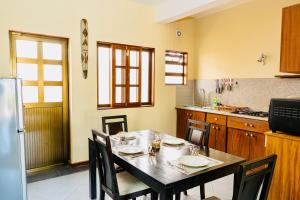 a kitchen with a table with chairs and a refrigerator at Bliss Retreat Apartment Near Super U in Grand Baie