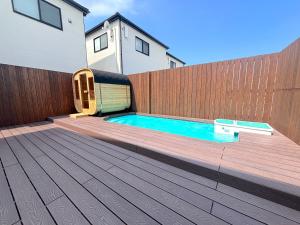 a backyard with a swimming pool and a wooden fence at -New Open- グランディオーソ沖縄プールヴィラ恩納14 in Onna