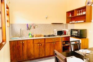 a kitchen with wooden cabinets and a sink and a microwave at Bliss Retreat Apartment Near Super U in Grand Baie +3 photos