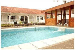 a swimming pool in front of a house at Villa Eden in Pointe-Noire