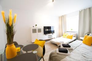 a living room with a couch and a table and yellow pillows at NEW! Modernes 2 Zimmer Apartment, Zentral, 6Pers in Essen