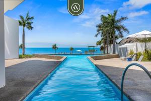 a swimming pool with the ocean in the background at Oceanfront 2 BR Condo with Beachclub in Cruz de Huanacaxtle