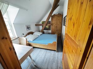 ein kleines Schlafzimmer mit einem Bett und einer Holztür in der Unterkunft Lüttje Paradies in Ruhwarden