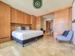 a bedroom with a large bed and a blue chair at Oceanfront 2 BR Condo with Beachclub in Cruz de Huanacaxtle +34 photos