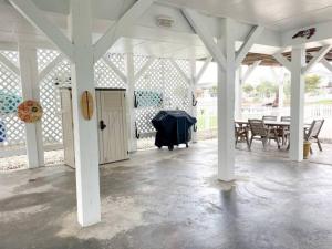 a white pavilion with a table and chairs at Pug Life - Walk to the Ocean in Ocean Isle Beach