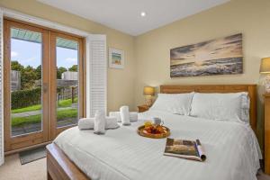 a bedroom with a bed with a tray of fruit on it at House 31 in Looe +33 photos