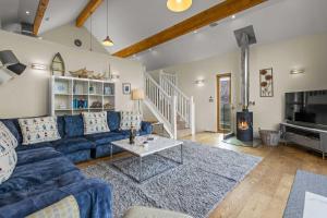 a living room with a blue couch and a table at House 31 in Looe
