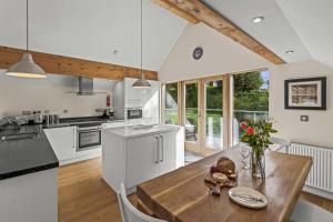 a kitchen with white cabinets and a wooden table at House 31 in Looe