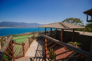 una escalera de madera con una valla y vistas al agua en Casa Natu Ilhabela Mirante, en Ilhabela