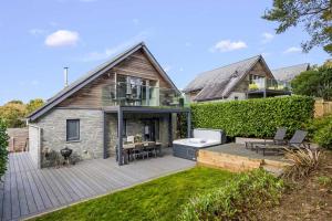 a backyard with a wooden deck and a house at House 31 in Looe