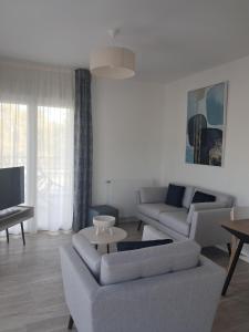 a living room with two couches and a tv at DOMITYS - Les Canotiers in Argenteuil