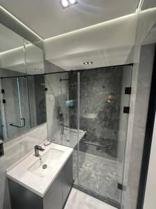 ein Badezimmer mit Waschbecken und Glasdusche in der Unterkunft TASHKENT CITY PREMIUM NRG U tower 8 floor, 106 in Taschkent + 7 Fotos
