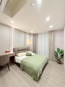 a bedroom with a bed and a desk and a bed sidx sidx sidx at 木光寓斗六全新電梯公寓含有客廳 in Douliu