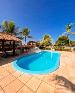 a swimming pool on a patio with palm trees at Pousada do Rancho in Barreirinhas