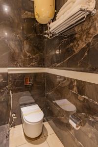 une salle de bain avec toilettes et un mur en marbre dans l'établissement The Nest Inn Resort, à Masinagudi
