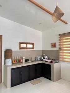 une cuisine avec un comptoir noir et blanc dans l'établissement Casa Ilios - a peaceful 2BR home in Poblacion 5, General Luna, à Catagnan 2 autres photos