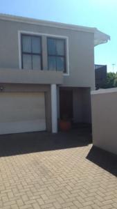 a large white house with a garage at StayNow Parklands in Cape Town