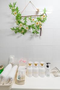 a bathroom counter with four bottles of soap and flowers at Metro Stay Daejeon Cozy home at transport hub in Daejeon